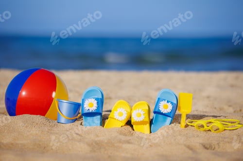 Preview: Kids flip-flops, beach ball and snorkel on the sand. Summer vacation concept