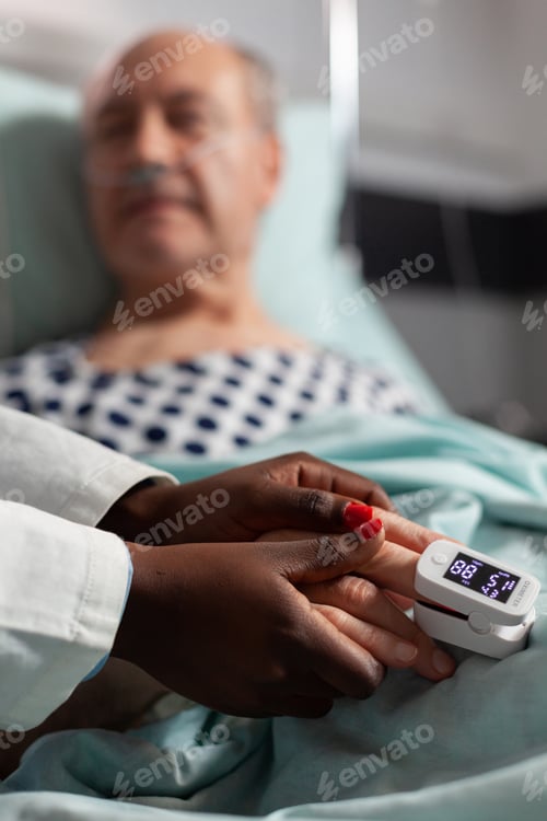 Preview: Friendly doctor reassuring sick old patient holding hands