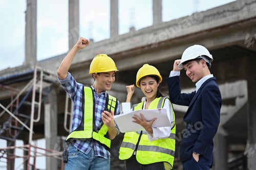 Preview: Construction workers in safety helmets celebrating a successful project on construction site