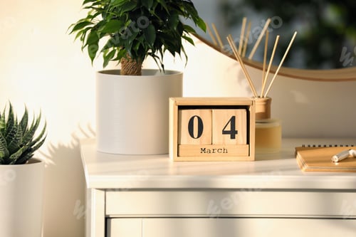 Preview: Wooden block calendar and plant on white table indoors