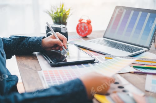 Preview: Graphic designer architects who work with laptops and color comparison tables for design work.