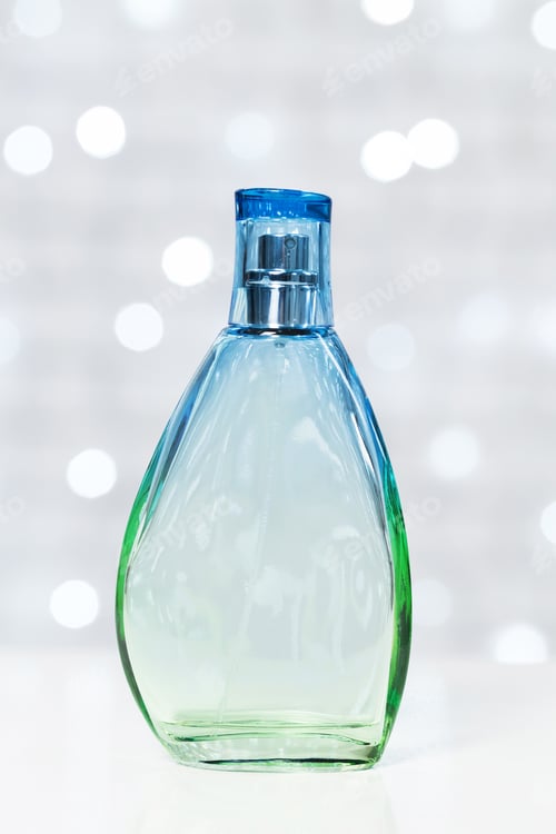Preview: Stylish green and blue scented bottle displayed on a bright background with shimmering lights