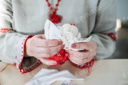 Preview: Crafting a white fabric doll with festive red accents. Highlighting folk art traditions and