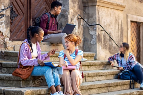Preview: Diverse group of students sitting on stairs takling and learning together.