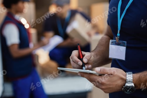 Preview: Close-up of delivery man using digital tablet.