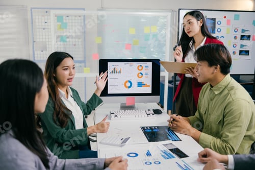 Preview: Asian business team analyzing charts on computer screen in office meeting