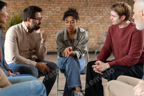 Preview: Diverse people sitting in circle supporting each other during group therapy session