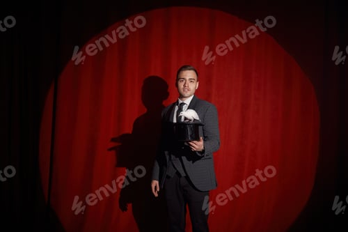 Preview: Elegant mysterious illusionist showing tricks with rabbit
