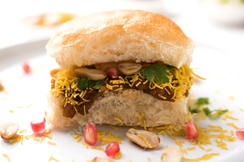 Delicious Vada Pav with Garnishes on White Surface