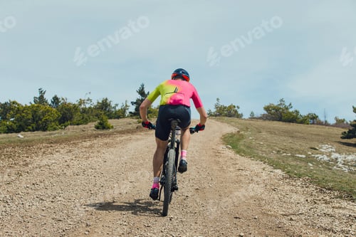 Preview: back male athlete on mountain bike