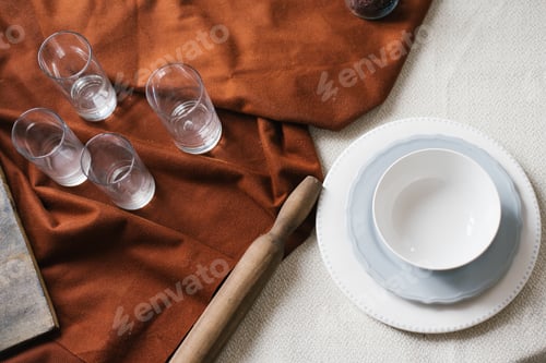 Preview: Table with a White Plate and a Bowl, and a Cloth with Glasses and a Rolling Pin