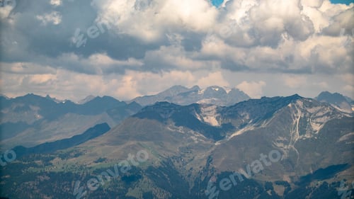 Preview: Scenic view of the Alps mountains under a cloudy sky