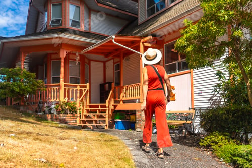 Preview: Tourist walking away from colorful victorian house in chemainus, british columbia