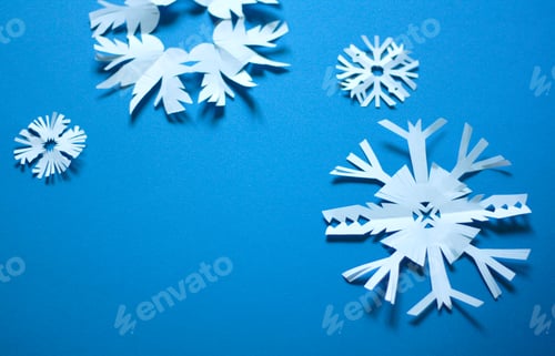 Preview: White paper craft snowflakes on a blue background