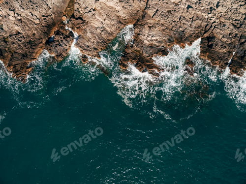 Preview: Bird's eye view of clear blue waters with coral reefs and rocks on a tropical island.