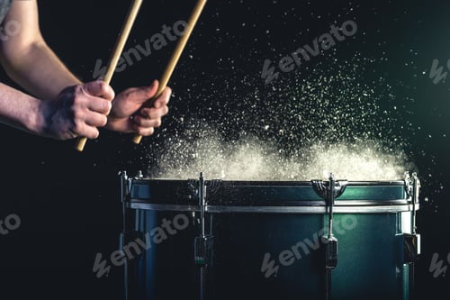 Preview: A man plays a musical percussion instrument with sticks on a dark background.