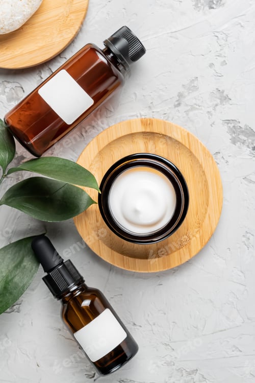 Preview: Skincare product set for face, essential oil bottle , cream jar, serum with dropper on concrete back