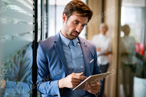 Preview: Young happy business woman working with tablet in corporate office