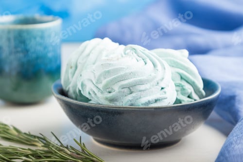 Preview: Blue colored homemade zephyr or marshmallow with cup of coffee on white wooden background