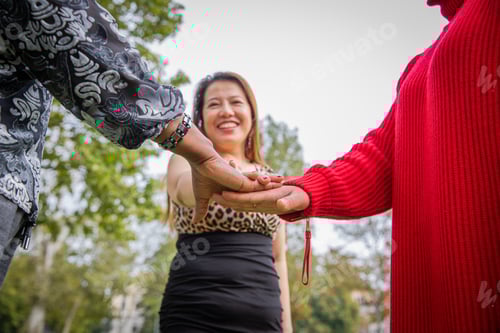 Preview: Three women of different ethnicities join hands as a sign of unity and strength.