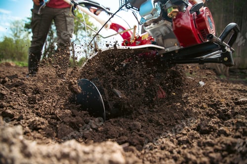 Preview: Farmer using tiller on a plowed field