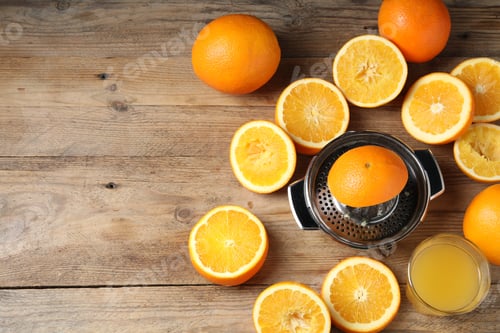 Preview: Freshly squeezed orange juice, fruits and juicer on wooden table, flat lay. Space for text
