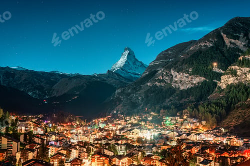 Preview: Zermatt rural town glowing in the alps with Matterhorn iconic peak in the night at Switzerland