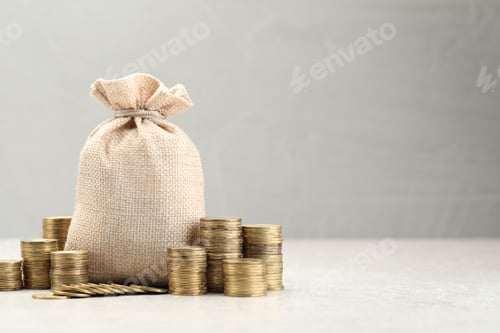 Preview: Bag and stacked coins on white table. Space for text