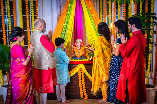 Preview: Indian Asian family performing Ganesh Puja at home in traditional attire, celebrating with devotion