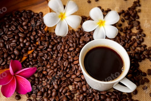 Preview: Cup of hot coffee on the table with scattered coffee beans and frangipani flowers