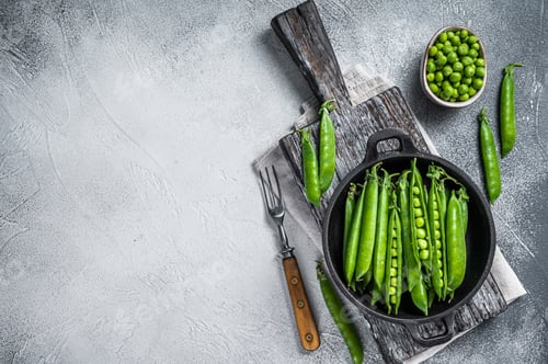 Preview: Unpeeled young green pea pods in a pan. White background. Top view. Copy space