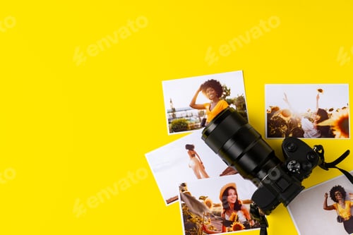 Preview: Photo camera with colorful printer photos on yellow background