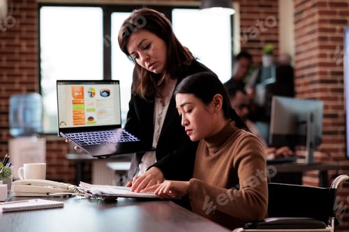 Preview: Female worker living with disability talking to colleague