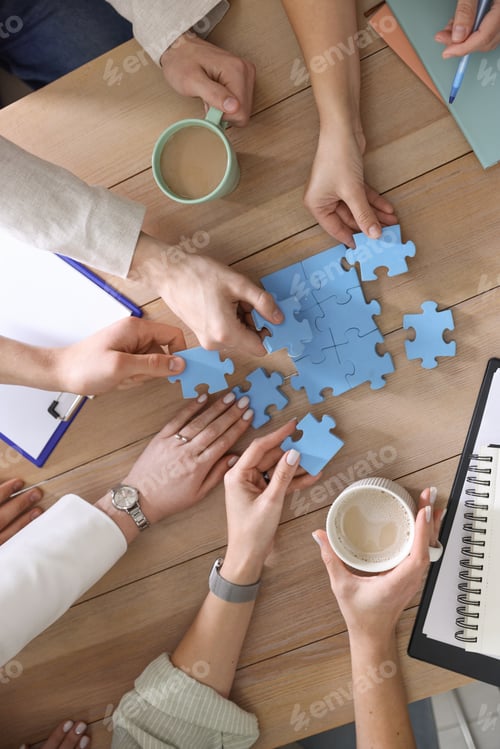 Preview: Unity concept. People putting puzzle pieces together at wooden table indoors, top view