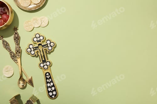 Preview: Liturgical bread, grapes in bowl and cross on green background, space for text