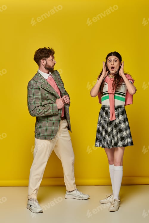 Preview: surprised man looking at shocked woman, yellow backdrop, open mouth, wow, amazed, emotional students