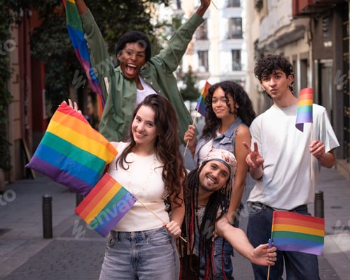 Preview: Young activists holding rainbow flags celebrating gay pride in city street