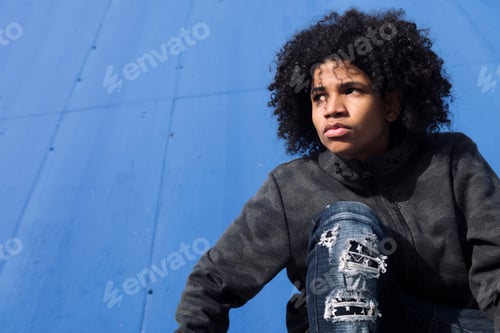 Preview: thoughtful curly haired teenager in informal wear