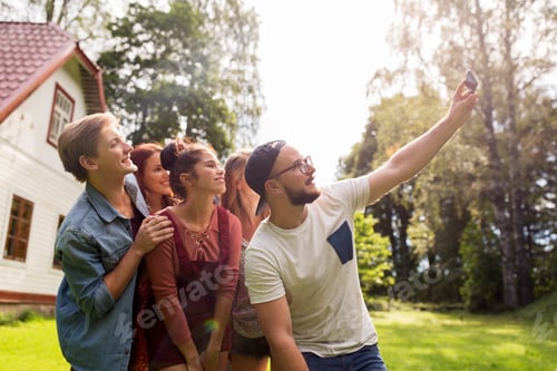 Preview: friends taking selfie at party in summer garden