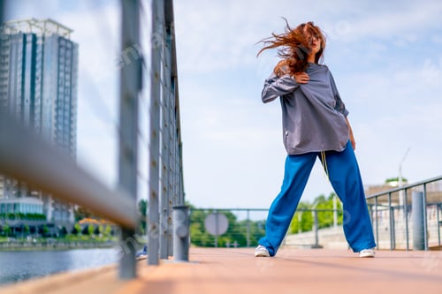 Preview: young red-haired street hip-hop dancer in sportswear dances impromptu dance us bridge