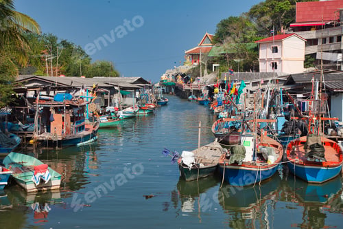 Preview: Amazing shot of many old wooden boats near a village near the reflective river in Thailand