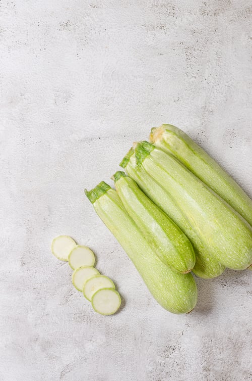 Preview: Slices of fresh vegetable marrow on light background.