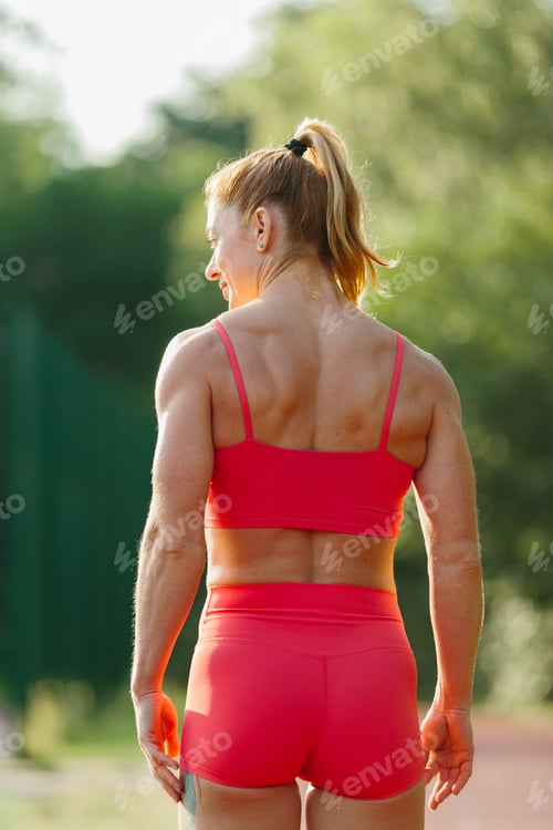 Preview: Fit woman training outdoors showing strong back
