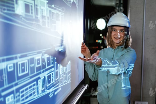 Preview: In white hard hat. Female architect is showing construction site plan for building on projector