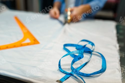 Preview: Seamstress cuts fabric with scissors in workshop