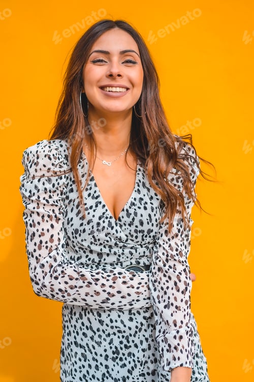 Preview: A pretty brunette smiling with a yellow background behind