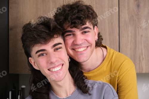 Preview: Happy gay couple smiling and embracing in kitchen