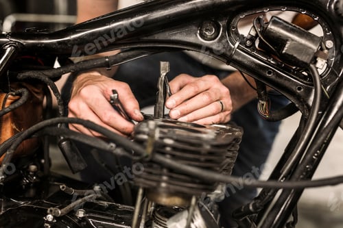 Visualização: Vista de perto de homem consertando motocicleta retrô