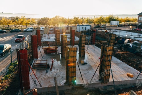 Preview: Construction site with steel formworks and reinforcing bars for pillars ready for concrete