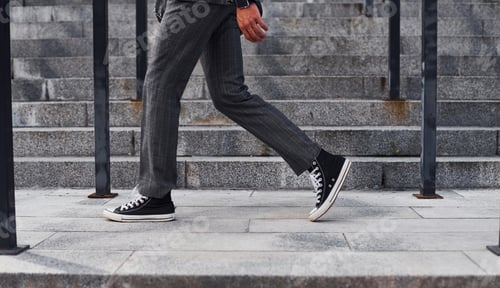 Preview: Close up view. Young successful businessman in grey formal wear is outdoors in the city